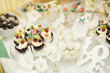 Obraz na płótnie Canvas Delicious sweets on wedding candy buffet with desserts, cupcakes
