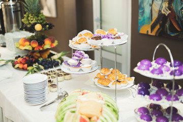 Delicious sweets on wedding candy buffet with desserts, cupcakes
