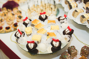 Delicious and tasty dessert table with cupcakes shots at reception closeup