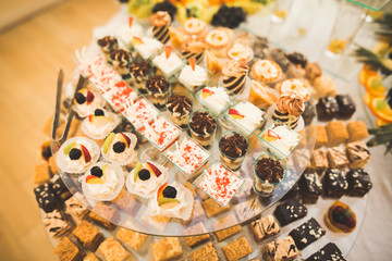 Delicious sweets on wedding candy buffet with desserts, cupcakes