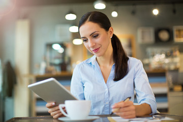 Obraz na płótnie Canvas Woman using digital tablet in cafe 