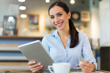 Obraz na płótnie Canvas Woman using digital tablet in cafe 