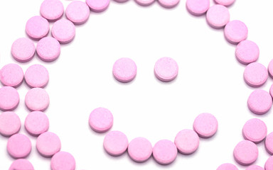 Smile face of pink pills  on white background. Tablets of drug for asthma treatment