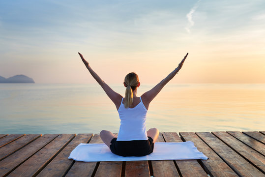 Schlanke Frau macht Yoga &Uuml;bung am Meer