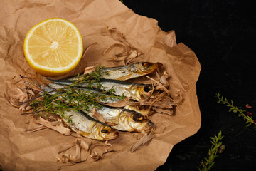 Smoked baltic herring on a paper with filings and lemon