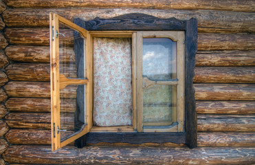 Rural window. Rural window of a wooden cottage with curtains
