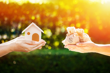 Loan or save for buy a house and real estate concept, Man and women hand holding money bags and a...