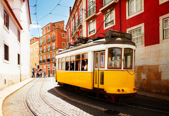 Plakat yellow tram on narrow street of Alfama district, Lisbon, Portugal, retro toned