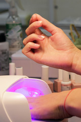 Obraz na płótnie Canvas drying and fixing a transparent base base applied to the nails before using shellac with an ultraviolet lamp