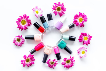 Choose nail polish for manicure. Bottles of colored polish on white background top view
