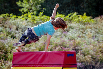 Girl Child Practicing Parkour Gymnastics Outside - Powered by Adobe