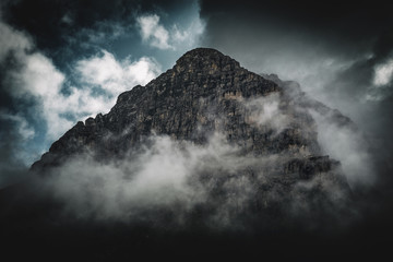 Dark, stormy fog shrouded rocky mountain peak