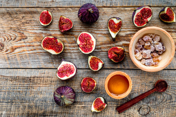 Make jam. Fresh blue figs in bowl, sugar and honey on wooden background top view