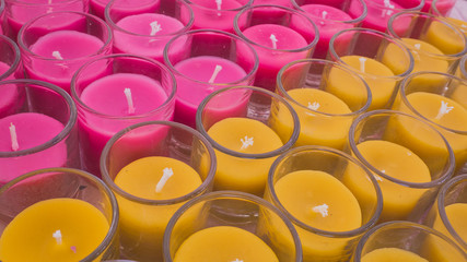 pink and yellow glass of candle close up