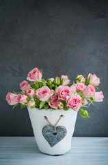 Pink roses in concrete pot