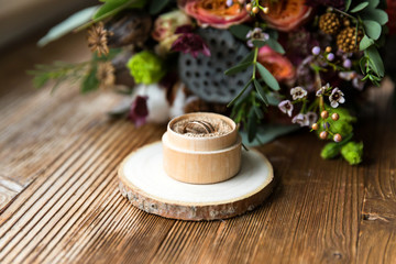 Wedding rings in the wooden box with fall bridal bouquet