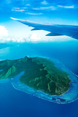 View from plane window flying over Moorea island, Tahiti, French Polynesia. Exotic luxury vacation...