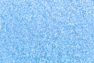 Fototapeta na wymiar Winter snow texture blue background with small snowflakes for christmas concept, copy space for text message signs or advertisement. Frozen frost on cold window.