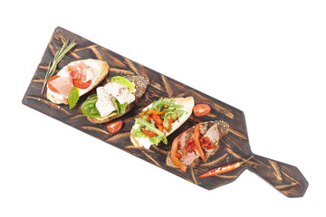 Four appetizing bruschettes on a wooden board