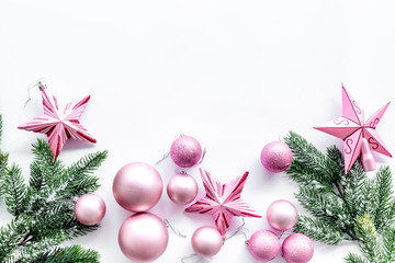 Christmas toys pattern. Pink stars and balls near pine branches on white background top view copyspace