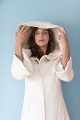 woman in a white coat with hood isolated on blue background