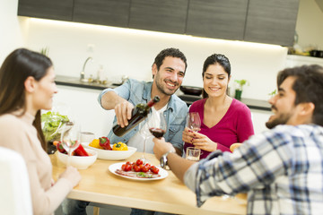 Group of young people drinking wine in the room