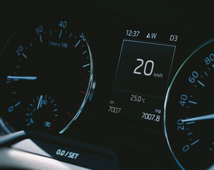 Car speedometer close-up with the needle pointing a 20 km/mph speed driving electric car digital display screen 