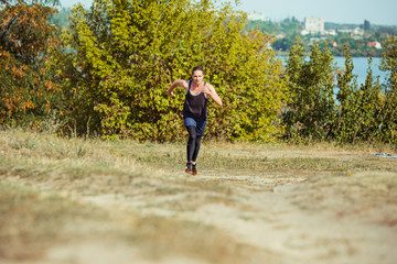 Obraz premium Running sport. Man runner sprinting outdoor in scenic nature. Fit muscular male athlete training trail running for marathon run.