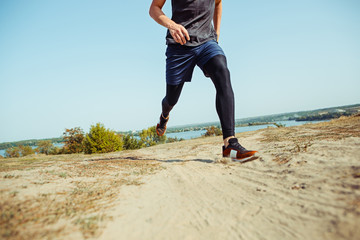 Running sport. Man runner sprinting outdoor in scenic nature. Fit muscular male athlete training trail running for marathon run.