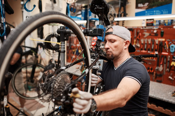 Bicycle mechanic in a workshop in the repair process