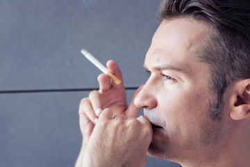 Thoughtful man smoking cigarette.