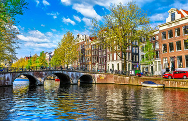 Bridge over channel in Amsterdam Netherlands houses river Amstel - obrazy, fototapety, plakaty