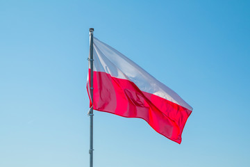 Naklejka na ściany i meble Polish national flag and blue spring sky
