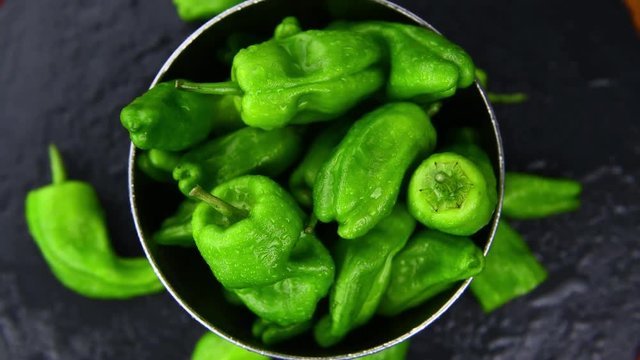 Rotating Pimientos on a dark and rustic slate slab (not loopable; 4K)