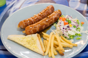 Grilled sausage with sauce and Fresh salad and French fries