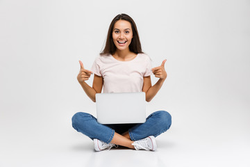 Portrait of a happy young asian girl pointing finger