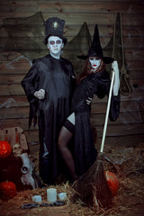 Halloween Holiday witch with a broom and a sorcerer in a hat