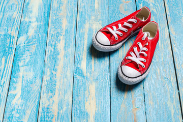 red sneakers on wooden background.