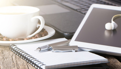 office table with notebook, computer keyboard, mouse, cup of coffee, tablet pc and smartphone. copy space