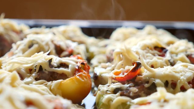 steaming, hot, freshly baked, stuffed zucchini on a baking sheet. close-up of steam from a hot dish. 4k, slow-motion