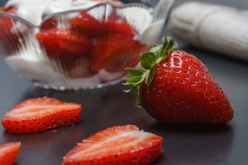 Delicious fresh strawberry with cream in a klemanke and sliced on a table with a vintage spoon