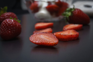Delicious fresh strawberry with cream in a klemanke and sliced on a table
