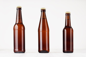 Collection brown beer bottles  500ml and 330ml mock up. Template for advertising, design, branding identity on white wood table.