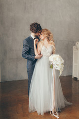 wedding in European style, beautiful couple in the Studio with a small dog