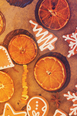christmas gingerbread cookies with orange slices on cooking paper close up, retro toned