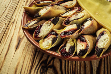 Pancakes with curd and raisins,Food photography. Thin pancakes with fillings,Stuffed pancakes on pottery, selective focus,curd.Pancakes with curd and berries ready for breakfast