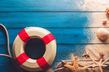 beach scene concept with sea shells and starfish on a blue wooden background © fergregory