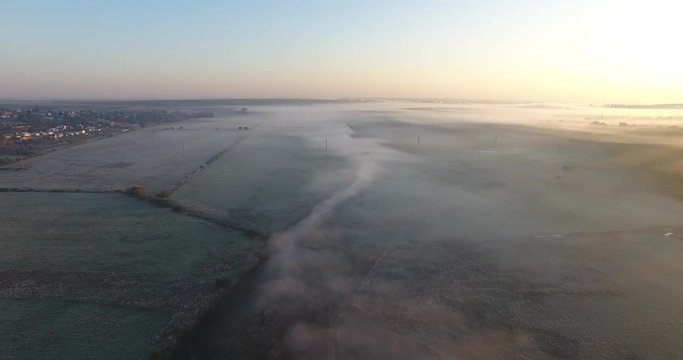Air view of the village with fog, inium, church and river