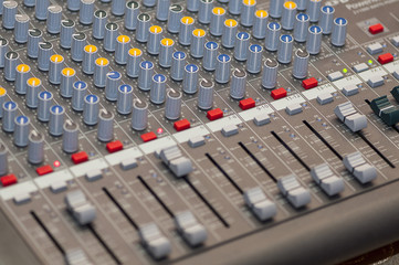 Close-up on knobs of an audio console. Digital audio board. Studio workstation. Mixing console.