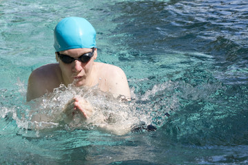 Fototapeta na wymiar The man swims in the pool